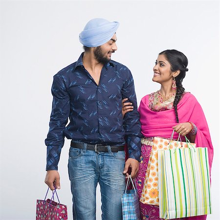 Couple carrying shopping bags and smiling Stock Photo - Premium Royalty-Free, Code: 630-03482879