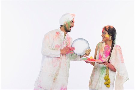 simsearch:630-03481384,k - Man playing a tambourine with a woman holding a tray of Holi colors Foto de stock - Royalty Free Premium, Número: 630-03482897