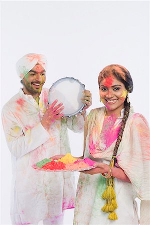 simsearch:630-03480216,k - Man playing a tambourine with a woman holding a tray of Holi colors Stock Photo - Premium Royalty-Free, Code: 630-03482898