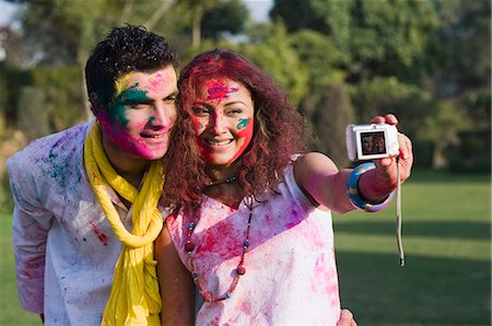 Couple taking a picture of themselves with a camera on Holi Stock Photo - Premium Royalty-Free, Code: 630-03482945