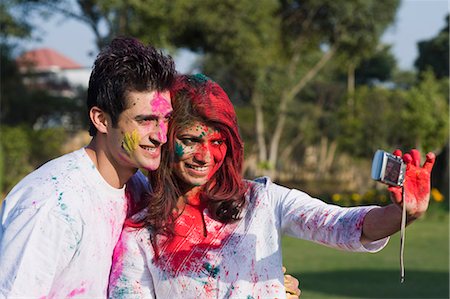 Couple taking a picture of themselves with a camera on Holi Stock Photo - Premium Royalty-Free, Code: 630-03482946