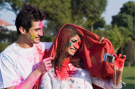 Couple taking a picture of themselves with a camera on Holi Foto de stock - Sin royalties Premium, Código: 630-03482947