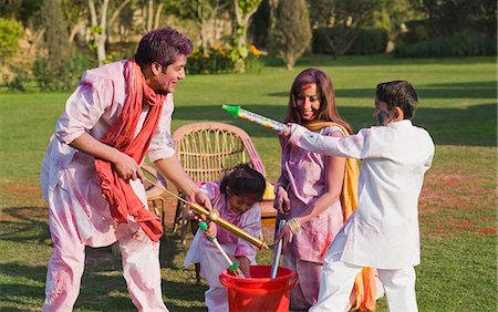 Family celebrating Holi with pichkaris Fotografie stock - Premium Royalty-Free, Codice: 630-03483027
