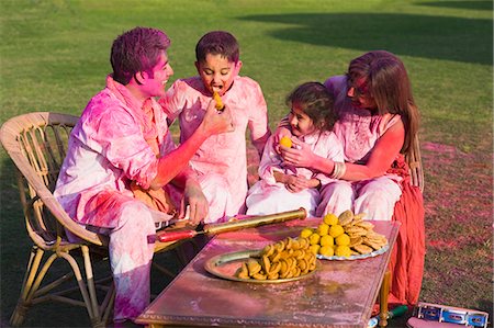 eating women expression - Family celebrating Holi with traditional Indian cuisines Foto de stock - Sin royalties Premium, Código: 630-03483059