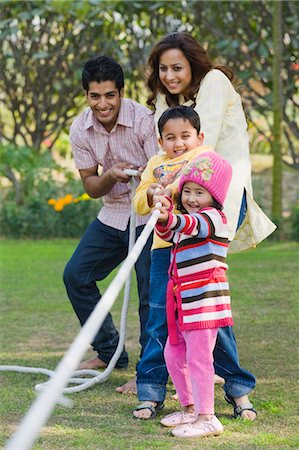 sports kids dad - Couples avec leurs enfants, jeu de tir à la corde dans un parc Photographie de stock - Premium Libres de Droits, Code: 630-03483087
