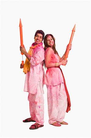 Couple playing Holi with pichkaris Stock Photo - Premium Royalty-Free, Code: 630-03483137