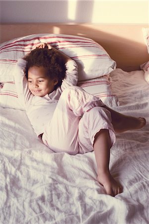 Little girl lying on bed in pajamas Stock Photo - Premium Royalty-Free, Code: 632-05400968