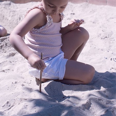 sandbox - Little girl playing in sand with stick Stock Photo - Premium Royalty-Free, Code: 632-05401132