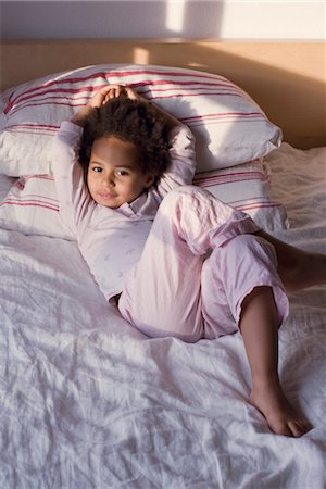 Little girl lying on bed in pajamas Stock Photo - Premium Royalty-Free, Code: 632-05401172