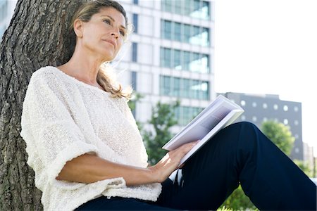 Woman with book looking away in thought Foto de stock - Sin royalties Premium, Código: 632-05401252