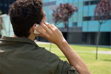 Man talking on cell phone, rear view Stock Photo - Premium Royalty-Free, Code: 632-05401312