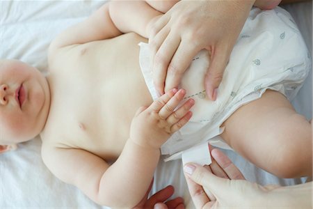 sanitario - Changing infant's diaper, cropped Foto de stock - Sin royalties Premium, Código: 632-05554064