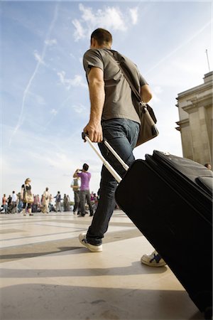 people with suitcase - Man walking with rolling luggage Stock Photo - Premium Royalty-Free, Code: 632-05554099