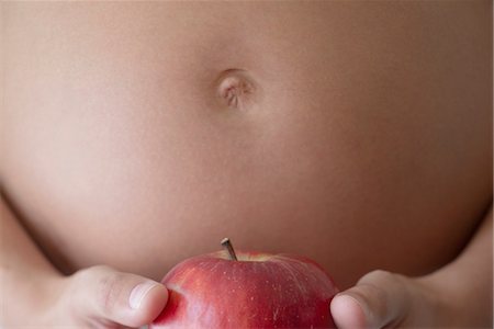 pregnant belly in labor - Pregnant woman holding apple, cropped Stock Photo - Premium Royalty-Free, Code: 632-05554152