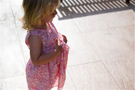 Little girl standing outdoors, looking away in thought Stock Photo - Premium Royalty-Free, Code: 632-05554176