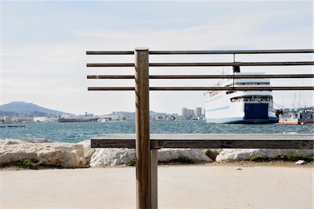 rimorchiatore - View of harbor through bench Fotografie stock - Premium Royalty-Free, Codice: 632-05553435