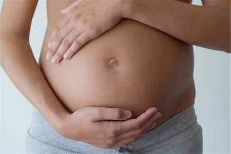 pregnant belly in labor - Pregnant woman holding her belly, cropped Stock Photo - Premium Royalty-Free, Code: 632-05553505