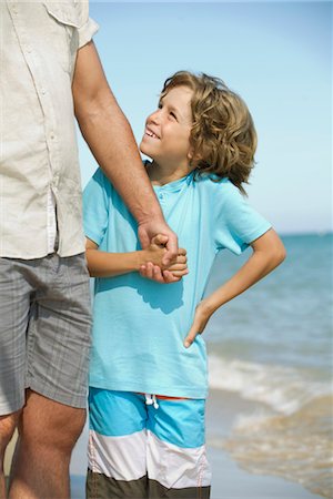 Boy holding father's hand at the beach Stock Photo - Premium Royalty-Free, Code: 632-05553523