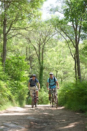pista de terra - Men riding bicycles in woods Foto de stock - Royalty Free Premium, Número: 632-05553625