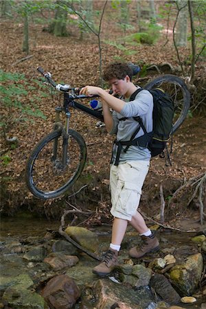 simsearch:632-05553953,k - Man carrying mountain bike across stream Stock Photo - Premium Royalty-Free, Code: 632-05553632