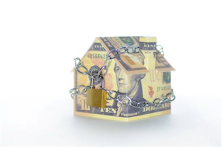 recesíon - Model house folded with dollar bills chained and padlocked Foto de stock - Sin royalties Premium, Código: 632-05553640