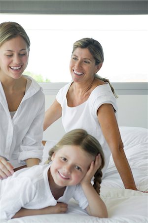 simsearch:685-03081464,k - Woman relaxing on bed with daughter and granddaughter Foto de stock - Royalty Free Premium, Número: 632-05553688