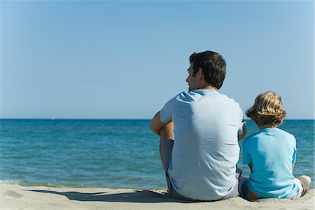 Father and son sitting together at the beach, rear view Stock Photo - Premium Royalty-Free, Code: 632-05553826