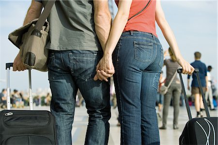 people with suitcase - Couple walking outdoors with rolling luggage Stock Photo - Premium Royalty-Free, Code: 632-05553832