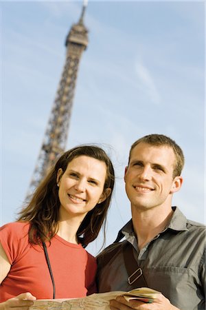 Couple holding map in front of Eiffel Tower, Paris, France Stock Photo - Premium Royalty-Free, Code: 632-05553930