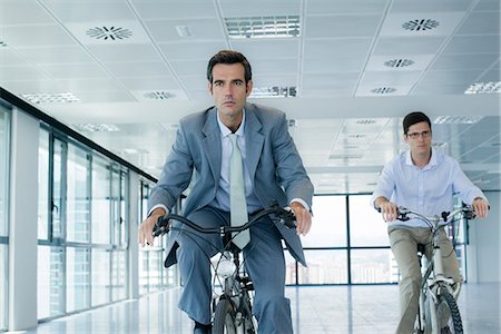 Businessmen riding bicycles indoors Stock Photo - Premium Royalty-Free, Code: 632-05604023