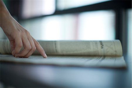 Hand pointing at newspaper, backlit, cropped Foto de stock - Royalty Free Premium, Número: 632-05604046