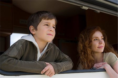 Young boy and mother looking out motor home window Foto de stock - Royalty Free Premium, Número: 632-05604066