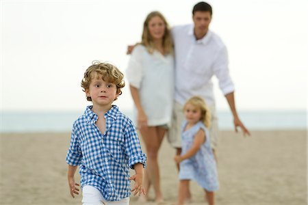 simsearch:632-05553829,k - Petit garçon marche devant sa famille à la plage Photographie de stock - Premium Libres de Droits, Code: 632-05604102