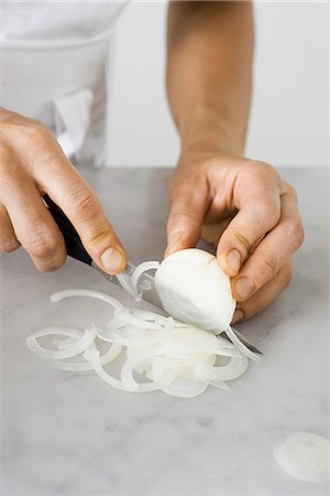 slicing vegetables - Slicing an onion Stock Photo - Premium Royalty-Free, Code: 632-05604292