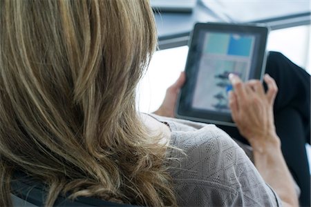 people over 50 - Woman using digital tablet, over the shoulder view Stock Photo - Premium Royalty-Free, Code: 632-05604304