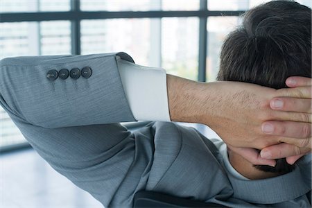 Businessman with hands behind head, rear view Foto de stock - Royalty Free Premium, Número: 632-05604467