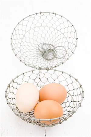 fio metálico - Fresh eggs in wire basket Foto de stock - Royalty Free Premium, Número: 632-05604585