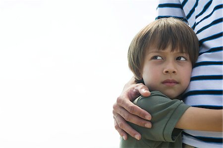 Boy embracing his father, looking away in thought Stock Photo - Premium Royalty-Free, Code: 632-05603822