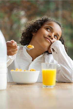 eat with cereal bowl with spoon - Girl daydreaming at breakfast table Stock Photo - Premium Royalty-Free, Code: 632-05603908