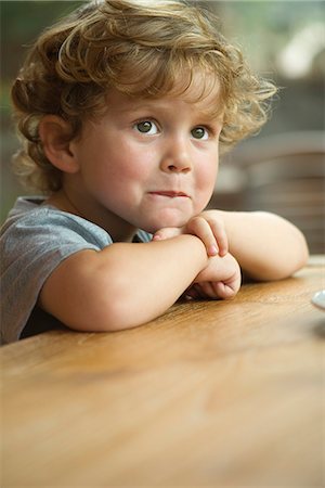 pouting - Little boy resting chin on arms, looking away in thought, portrait Stock Photo - Premium Royalty-Free, Code: 632-05603997