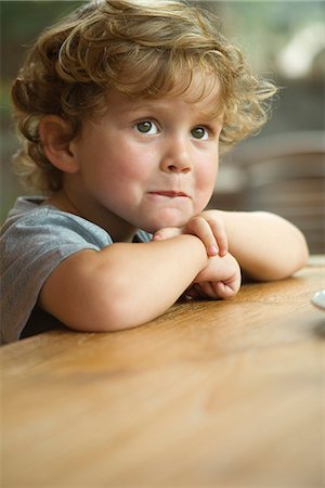 simsearch:632-05401219,k - Little boy resting chin on arms, looking away in thought, portrait Fotografie stock - Premium Royalty-Free, Codice: 632-05603997