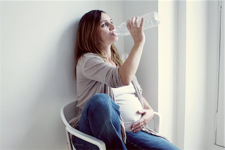 pregnant woman in chair - Pregnant woman drinking water from bottle Stock Photo - Premium Royalty-Free, Code: 632-05759465