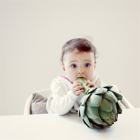 Infant biting fresh artichoke Stock Photo - Premium Royalty-Free, Code: 632-05759564