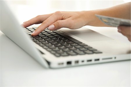 paying for purchase - Woman using laptop computer to make an internet purchase, cropped Stock Photo - Premium Royalty-Free, Code: 632-05759561