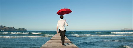 parasol - Man walking on pier with umbrella, rear view Foto de stock - Sin royalties Premium, Código: 632-05759616