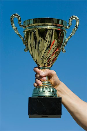 Man's arm holding up trophy Stock Photo - Premium Royalty-Free, Code: 632-05759682