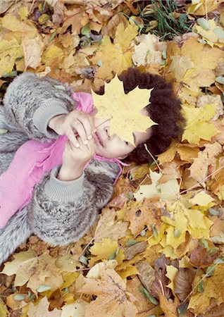 simsearch:632-05553831,k - Little girl lying on bed of autumn leaves Foto de stock - Sin royalties Premium, Código: 632-05759723