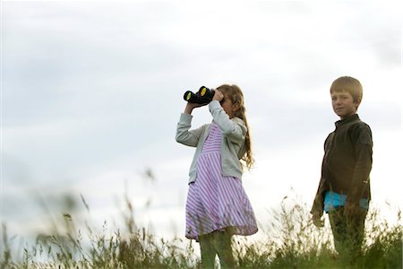 simsearch:633-05401630,k - Enfants debout dans champ, fille regardant dans les jumelles Photographie de stock - Premium Libres de Droits, Code: 632-05759774