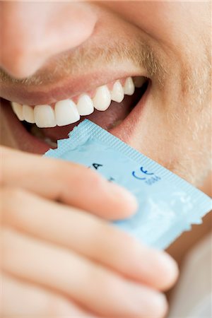 dientes - Man opening condom wrapper with his teeth, cropped Foto de stock - Sin royalties Premium, Código: 632-05759839