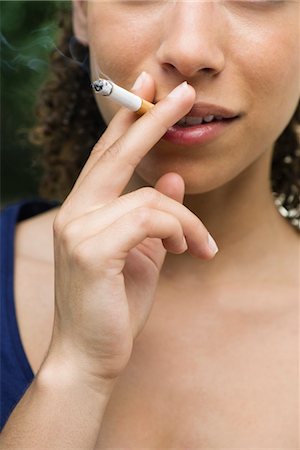 simsearch:632-06317680,k - Young woman smoking cigarette, cropped Foto de stock - Sin royalties Premium, Código: 632-05759910